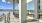 a building with a patio and tables overlooking a body of water